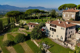 Vista aerea di Villa Di Valgiano e dei suoi giardini, con la piana di Lucca sullo sfondo.