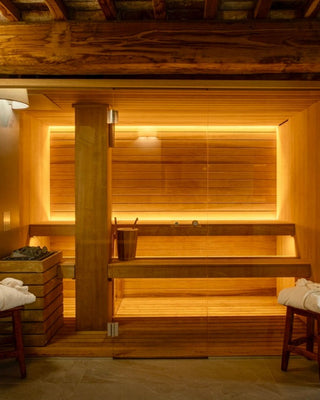 Sauna finlandese privata di Villa Di Valgiano, con panche in legno e porta in vetro.