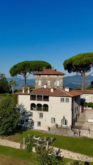 Vista aerea di Villa Di Valgiano, circondata da giardini, pini e cipressi sulle colline di Lucca.
